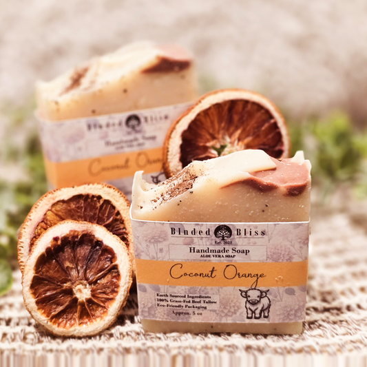 Coconut Orange handmade soap with creamy swirls, topped with coconut shell powder, and dried orange slices.