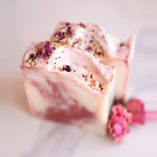 Rose Geranium handmade soap with pink and white swirls, topped with dried rose petals and botanicals.