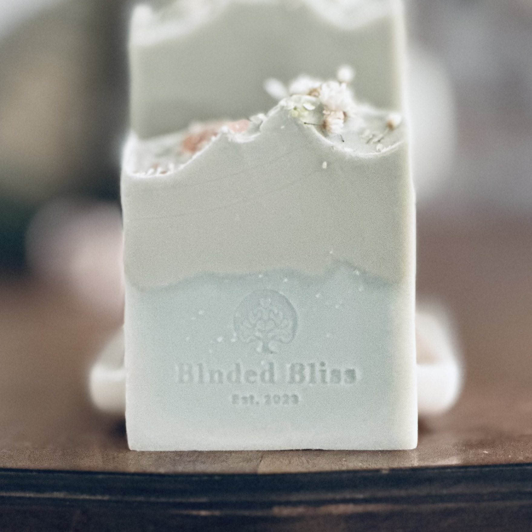 Close-up of Freya artisan soap by Blnded Bliss, natural aloe vera soap bar with green and cream tones, topped with delicate botanicals.