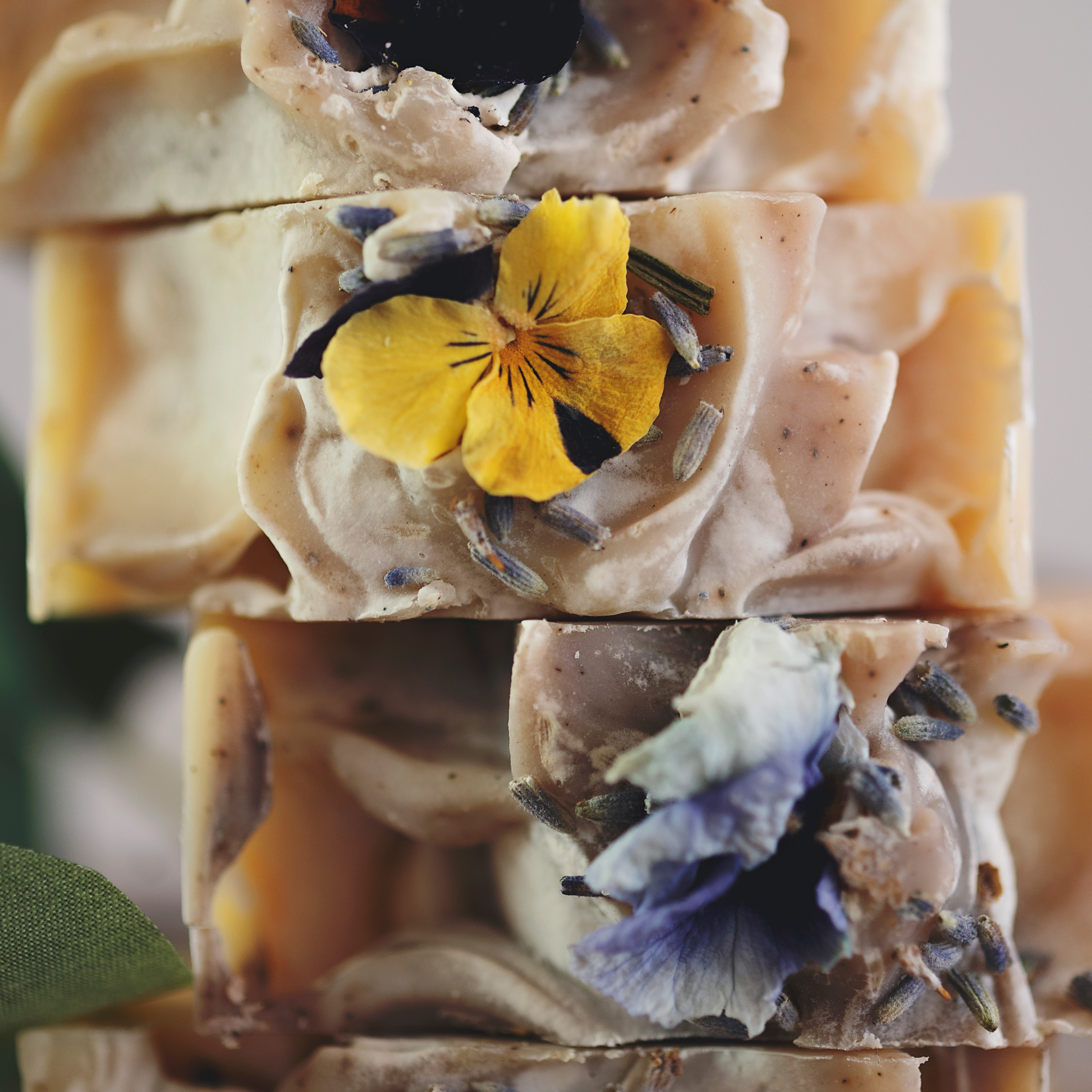 A close up view of Blnded Bliss Lavender Frankincense soap bars, botanicals prominent.