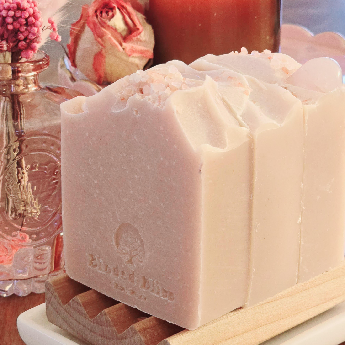 A side view of the Blush soap bars arranged on a wooden soap dish, highlighting their smooth texture, stamped Blinded Bliss logo, and natural elegance.