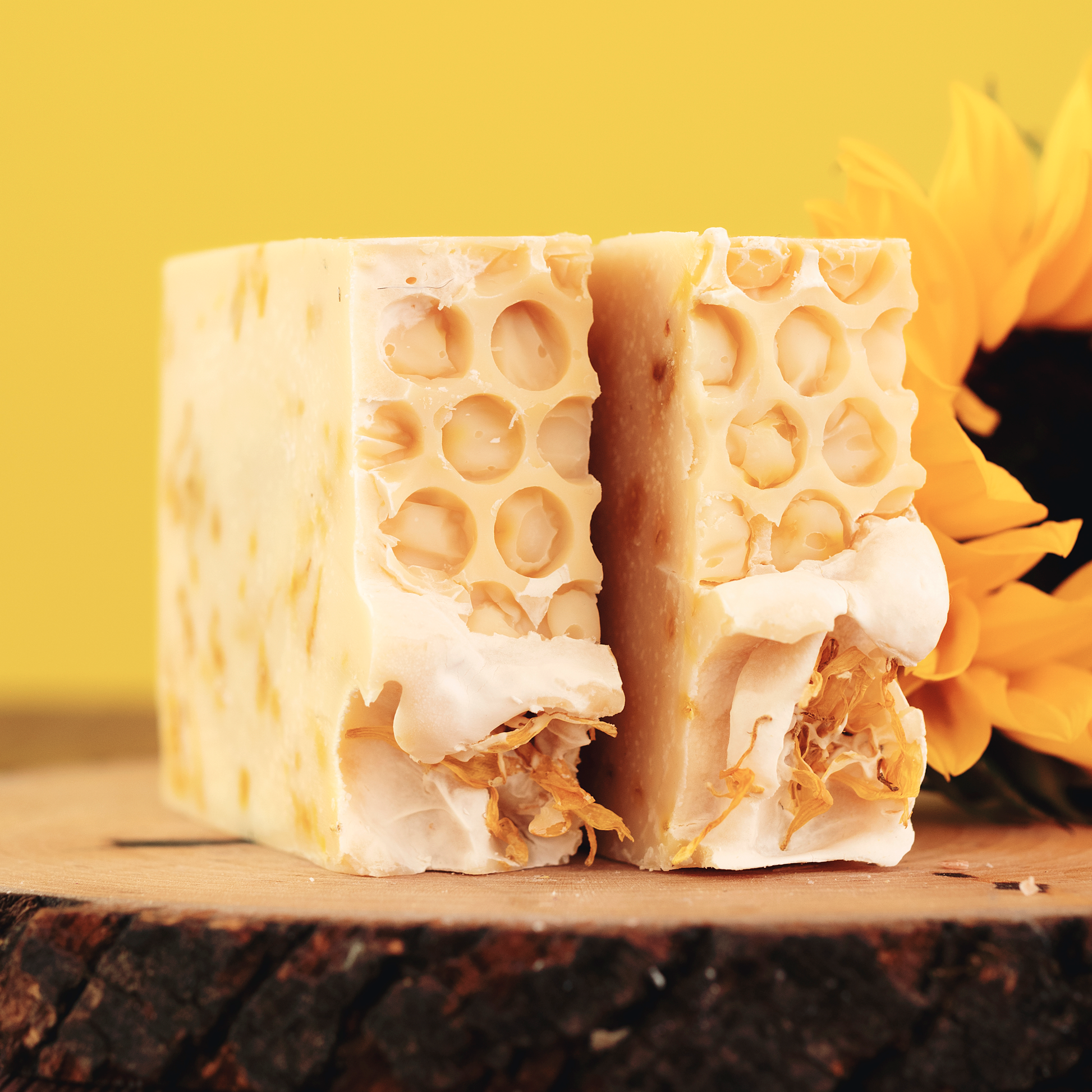 A side-view of Blnded Bliss Lemongrass Soap, a partial sunflower in the background. Photo by Emily Davis Photography